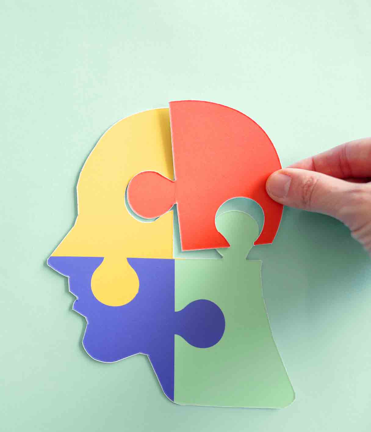Mental health spectrum depicted in a head shape with different colored puzzle pieces