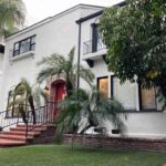 Photo of a structured sober living in Los Angeles with palm trees and green grass.